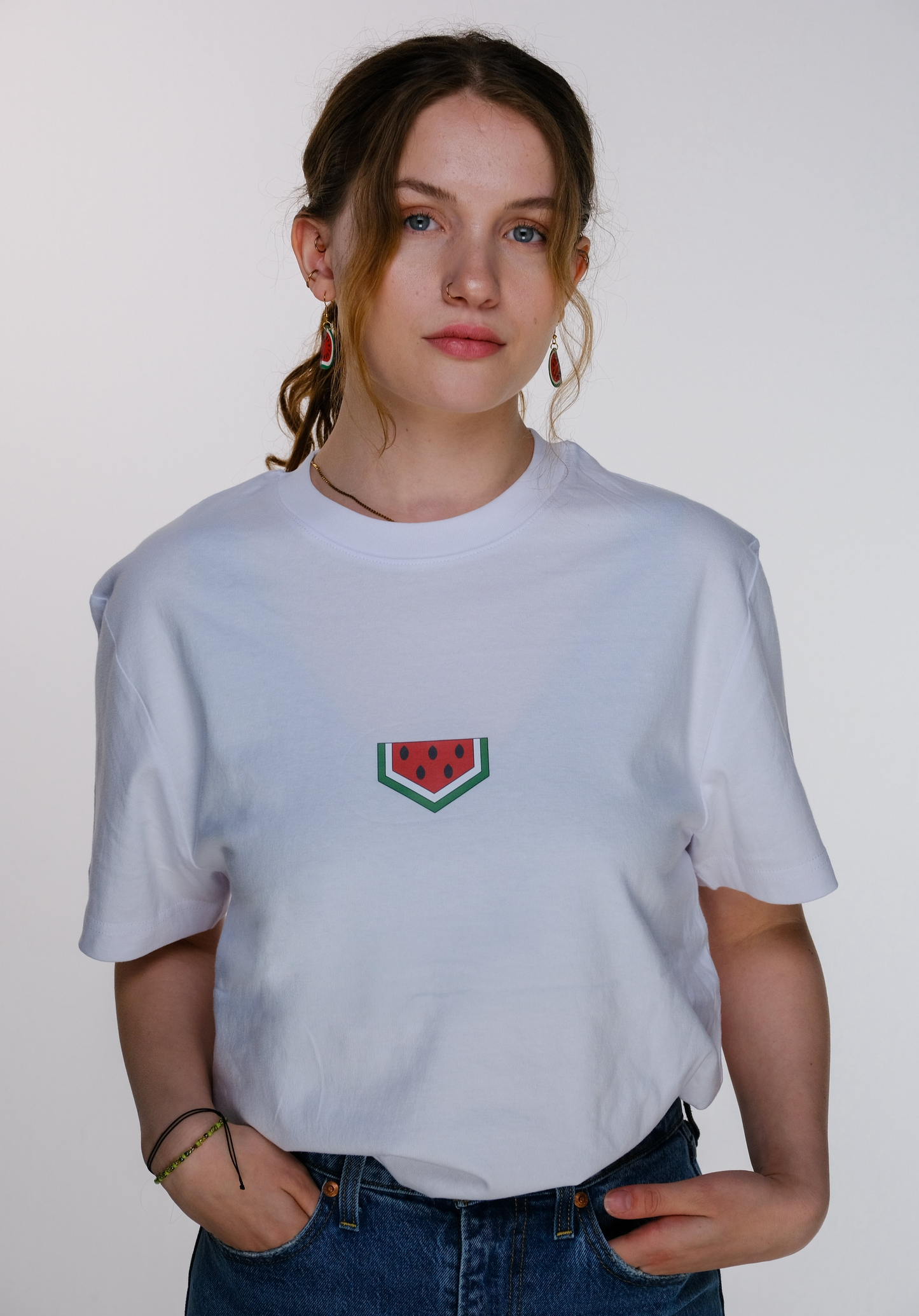 A young model wearing the watermelon T-shirt, standing confidently.
The red-green-black colors of the watermelon design evoke the Palestinian flag and resistance.