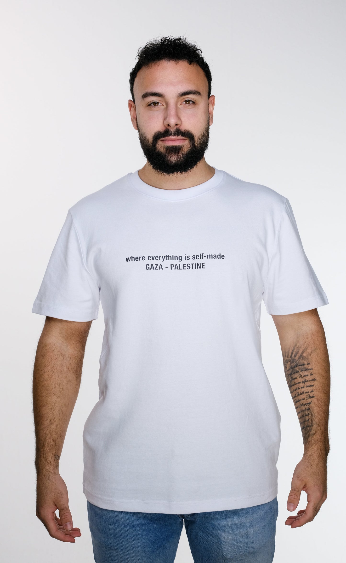 Model wearing the Khayyat T-shirt front view, showcasing the bold chest text design and relaxed oversized fit inspired by traditional Palestinian embroidery "Tatreez".