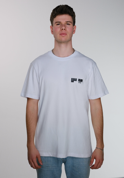 Front view of model wearing a white Resist T-shirt, featuring the Arabic letters "ي" and "س" subtly printed on the right chest, symbolizing resistance.