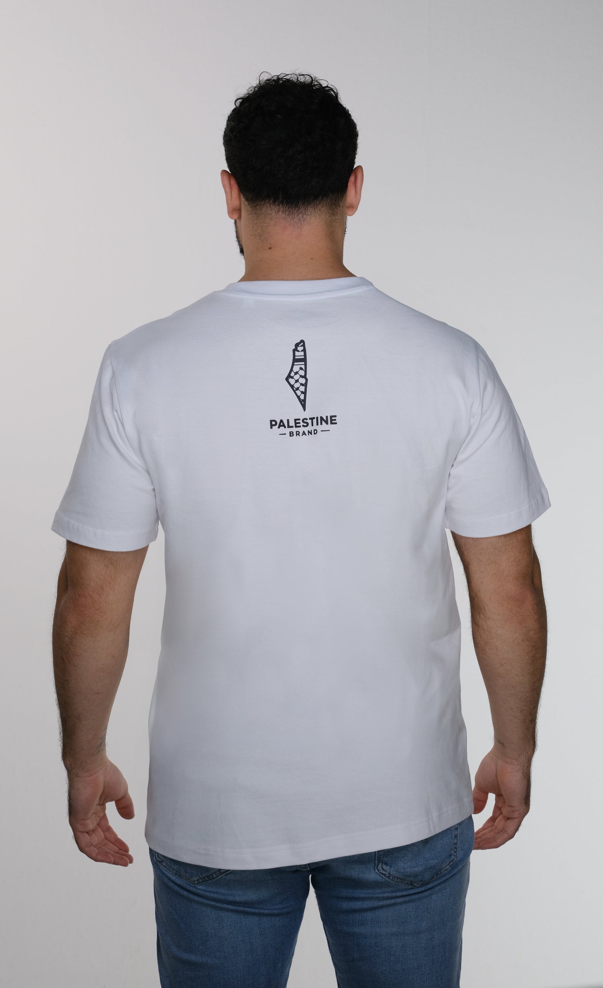 Model back view of  the sumud T-shirt which is featuring Palestine Brand logo design.
it is Palestine map with keffiyeh colors 